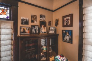 Wall with framed pictures and display cabinet